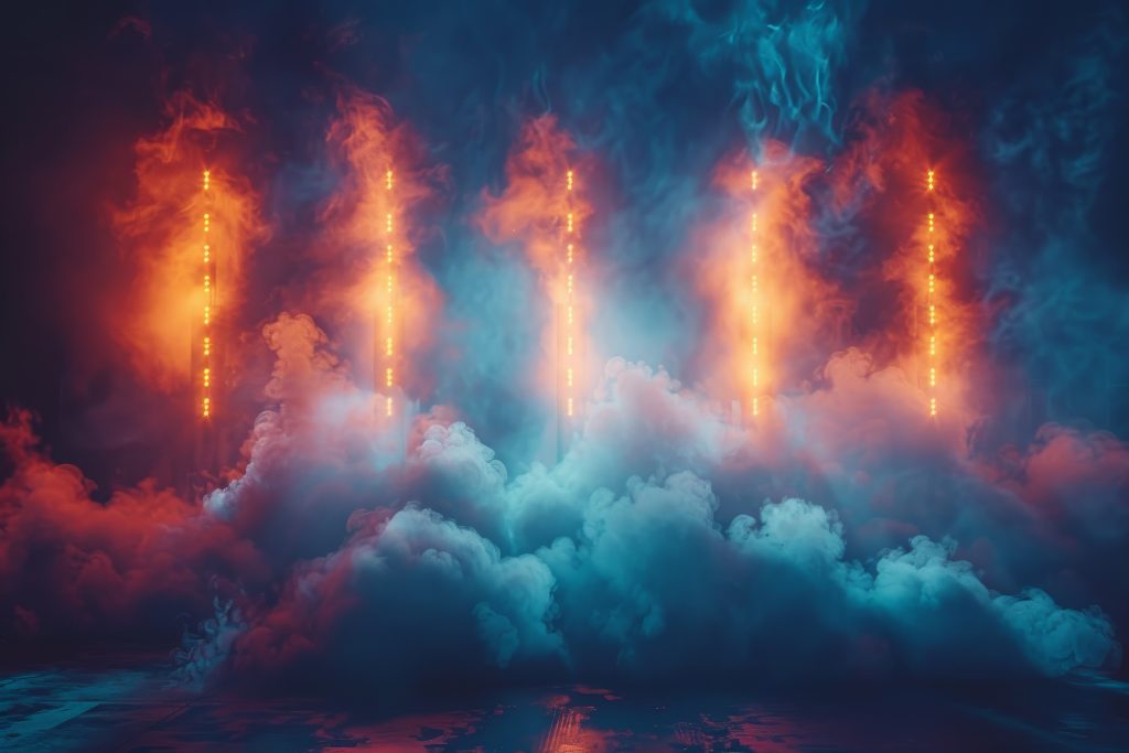 Intense lighting and fog on a stage giving a sense of a high-energy performance about to happen